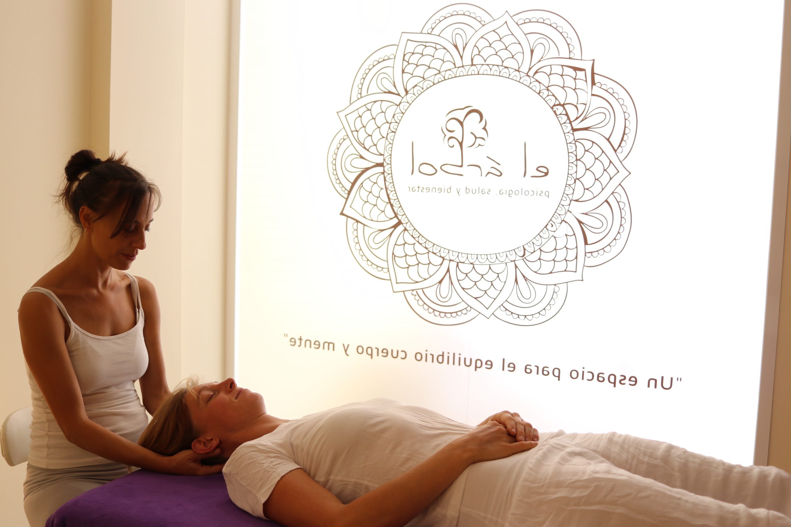 dos personas realizando una sesión de terapia craneosacral